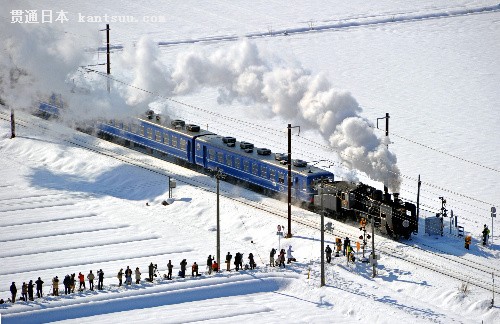 在大批摄影师的守望中，SL北琵琶湖号喷吐着白烟驰骋于雪原上=29日、滋贺县长浜市